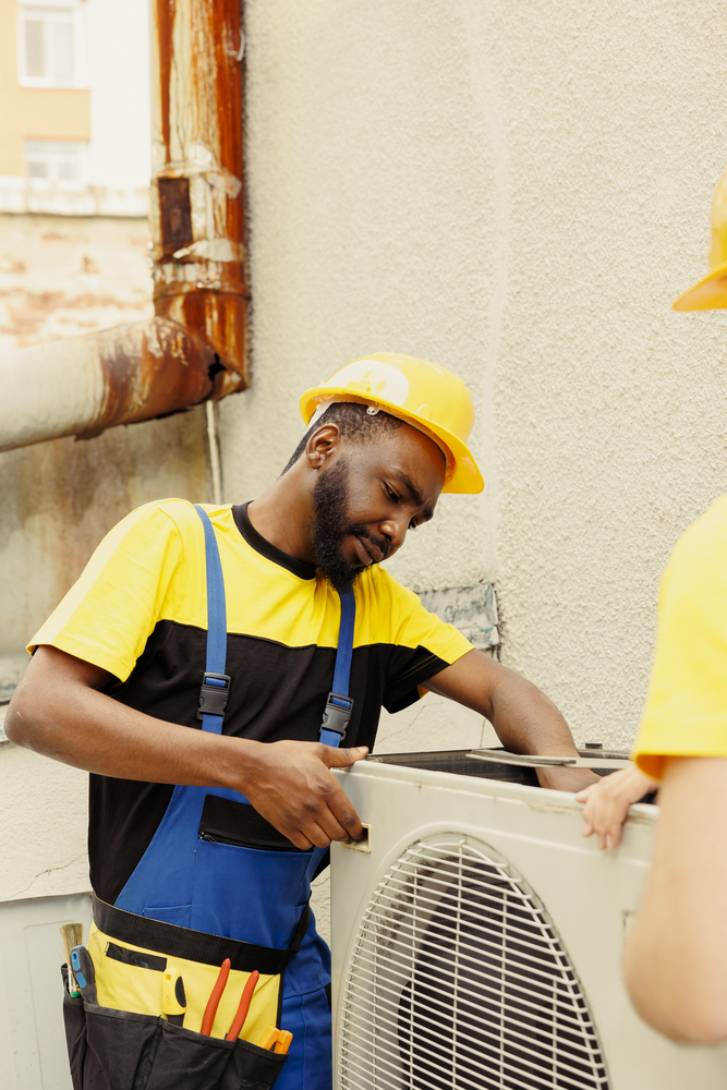 Repairmen disassembling air conditioner